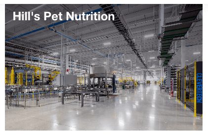 Interior of the Hill's Pet Nutrition manufacturing facility: a bright, polished production floor with stainless steel lines and yellow safety rails